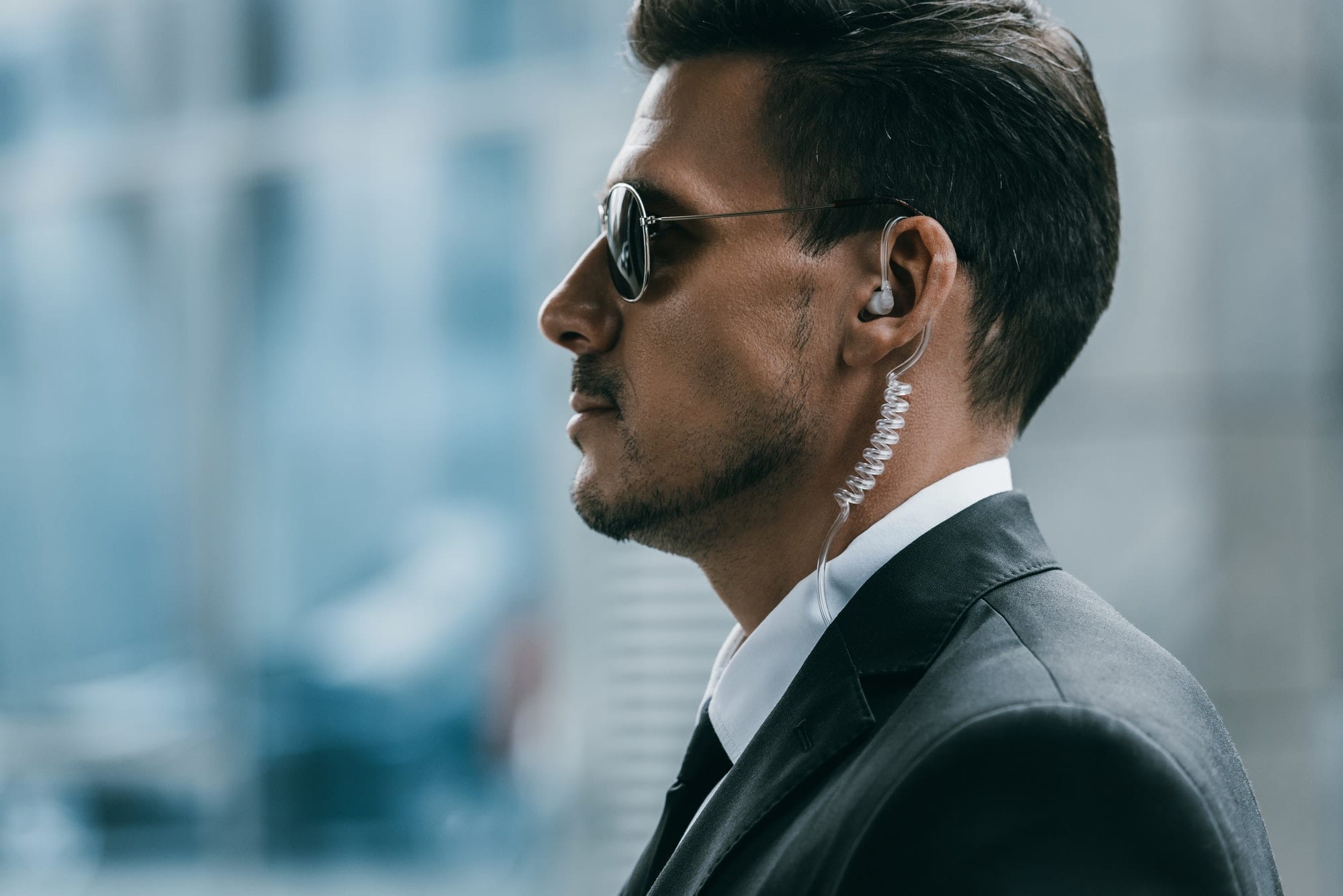 profile of handsome security guard with sunglasses and security earpiece