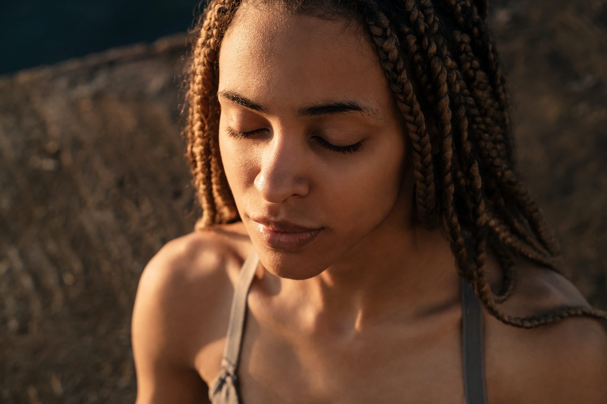 African woman practicing yoga meditation at the beach