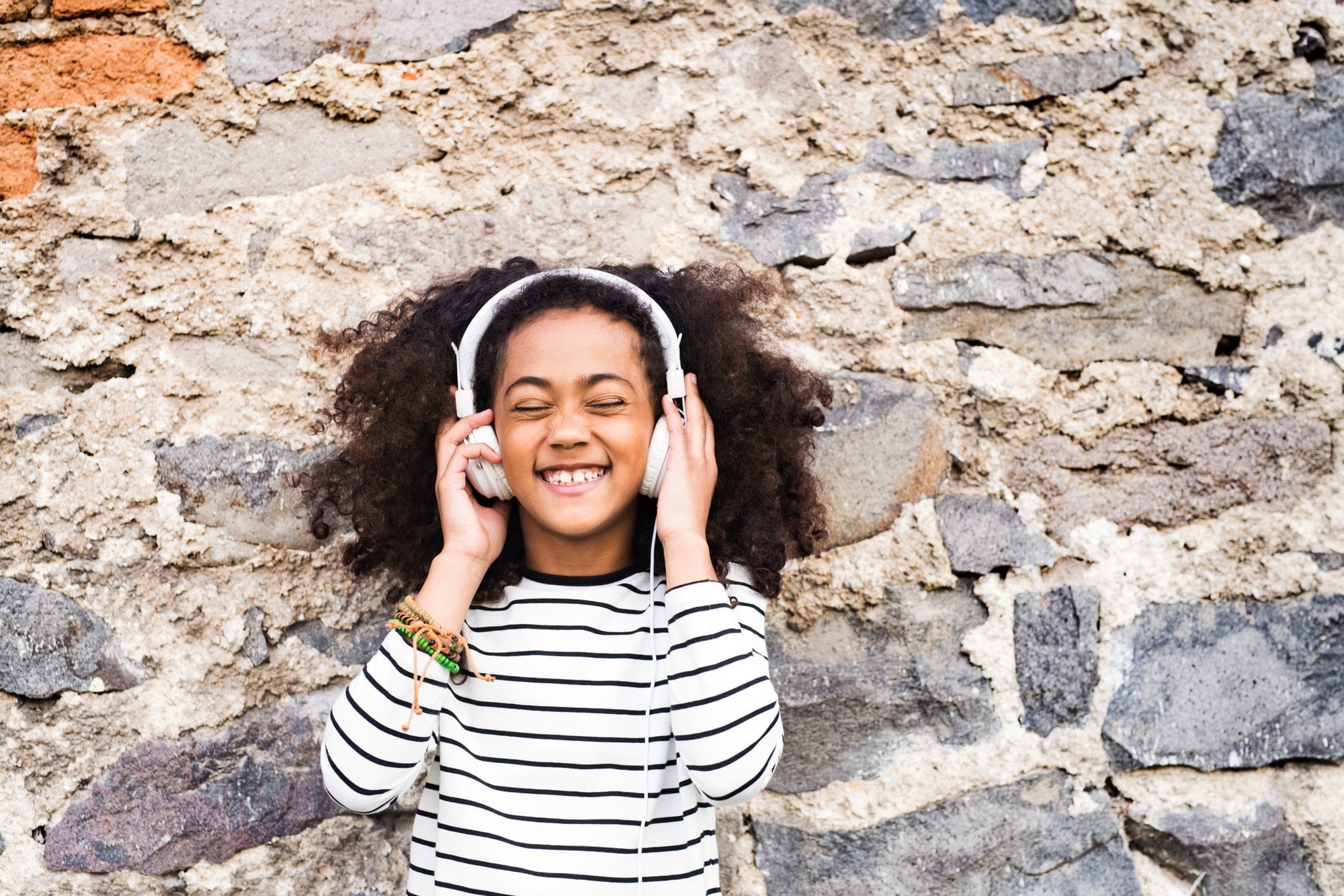 Beautiful african american girl with smart phone and earphones.