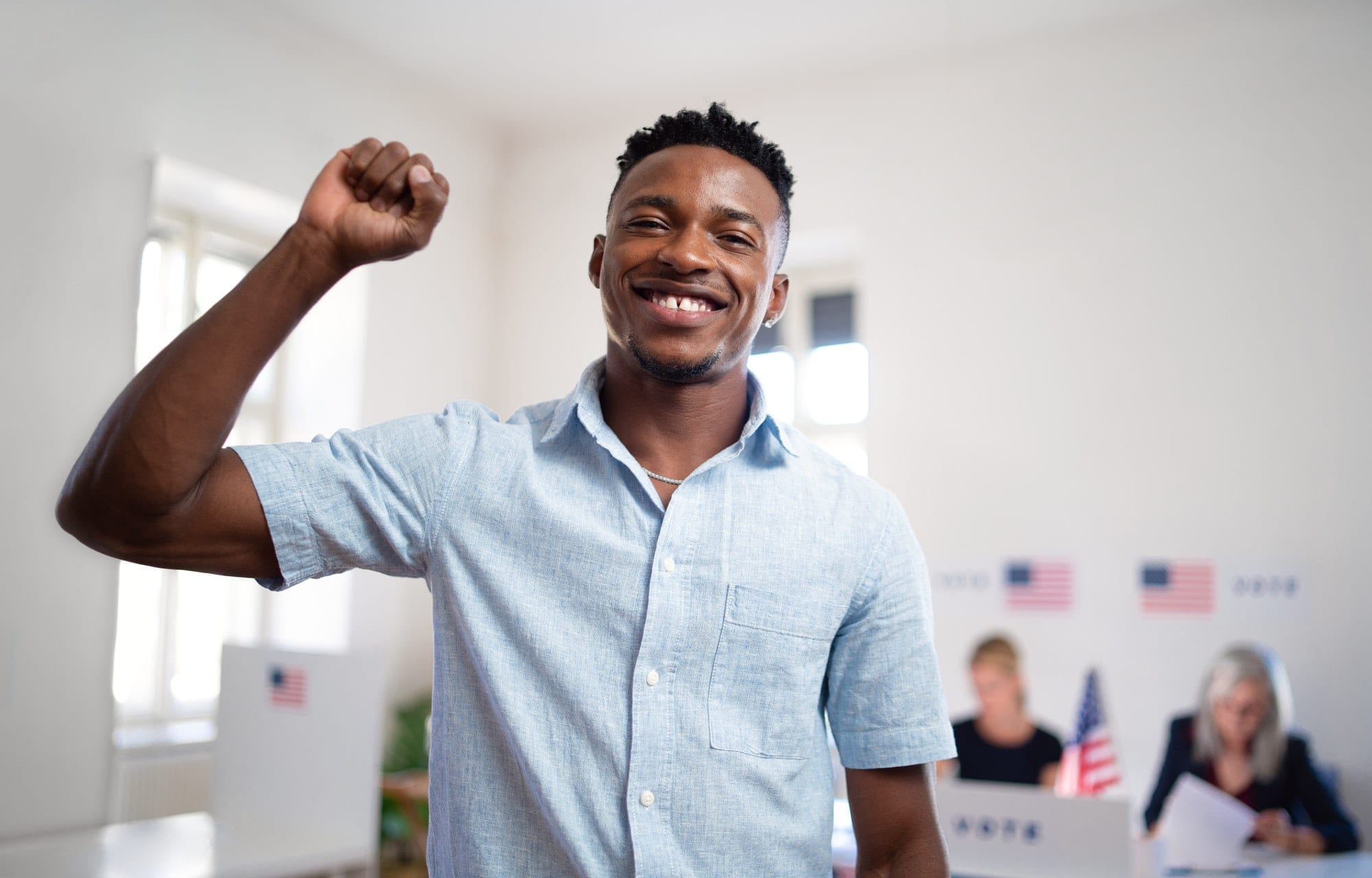 Happy african-american man voter looking at camera in the polling place, usa elections