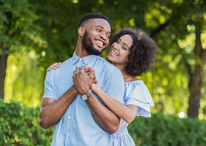 Loving african-american couple hugging in summer park