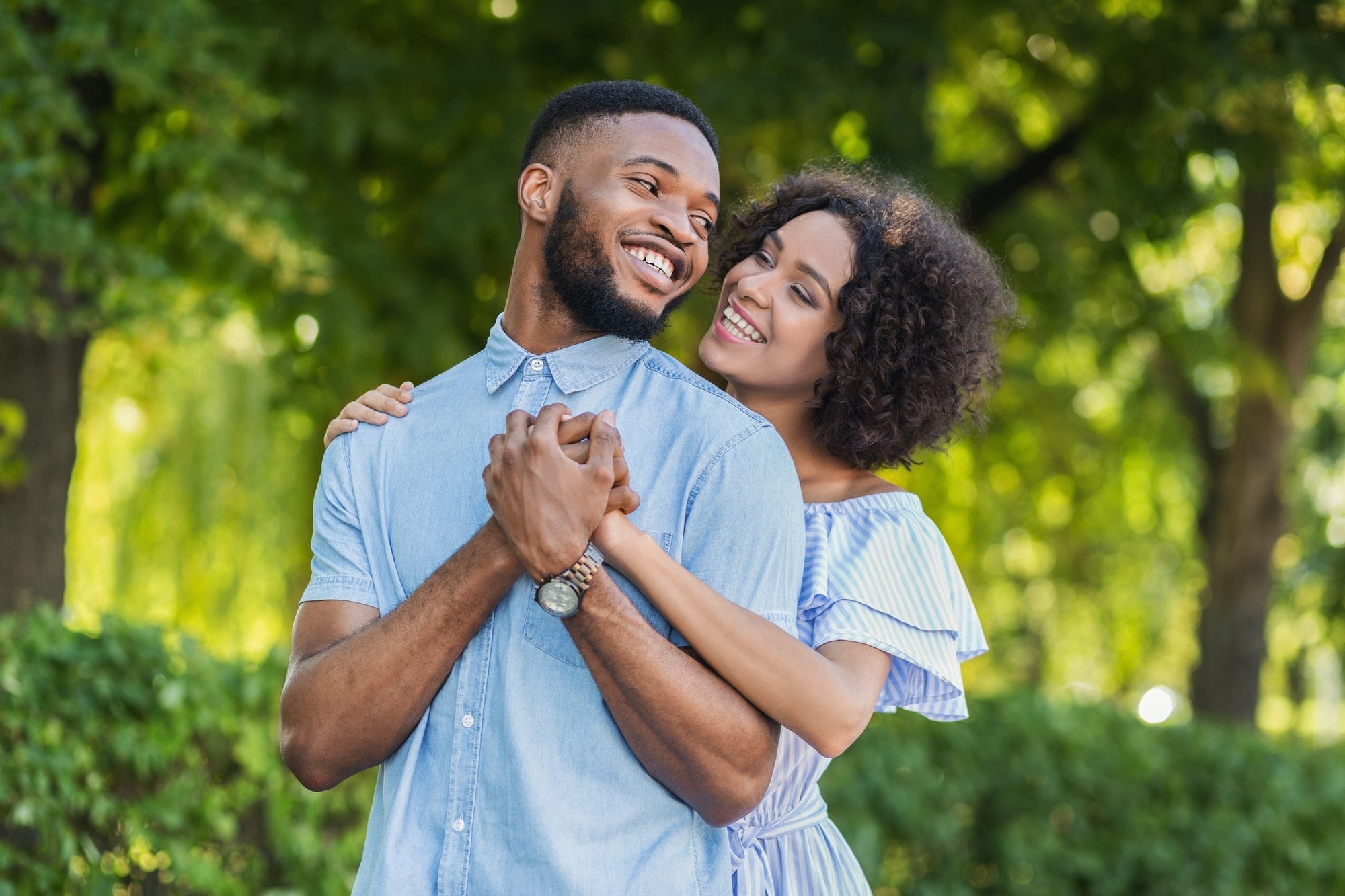 Loving african-american couple hugging in summer park