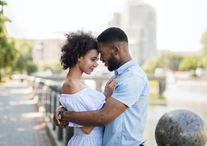 Loving african-american couple hugging on the bridge
