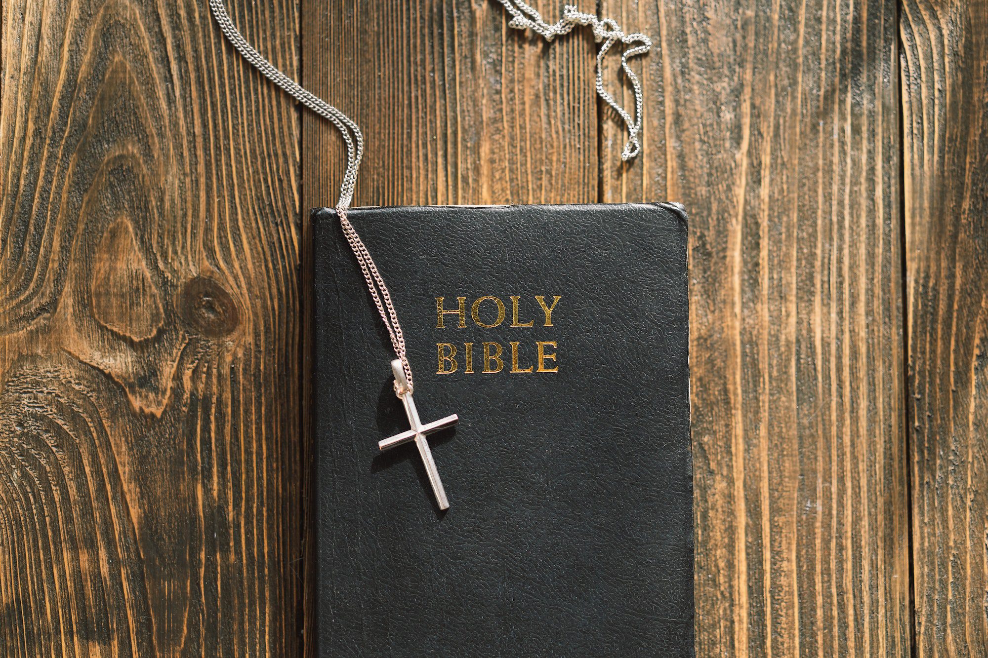 Bible and cross on a wood background. Study Bible worship concept.