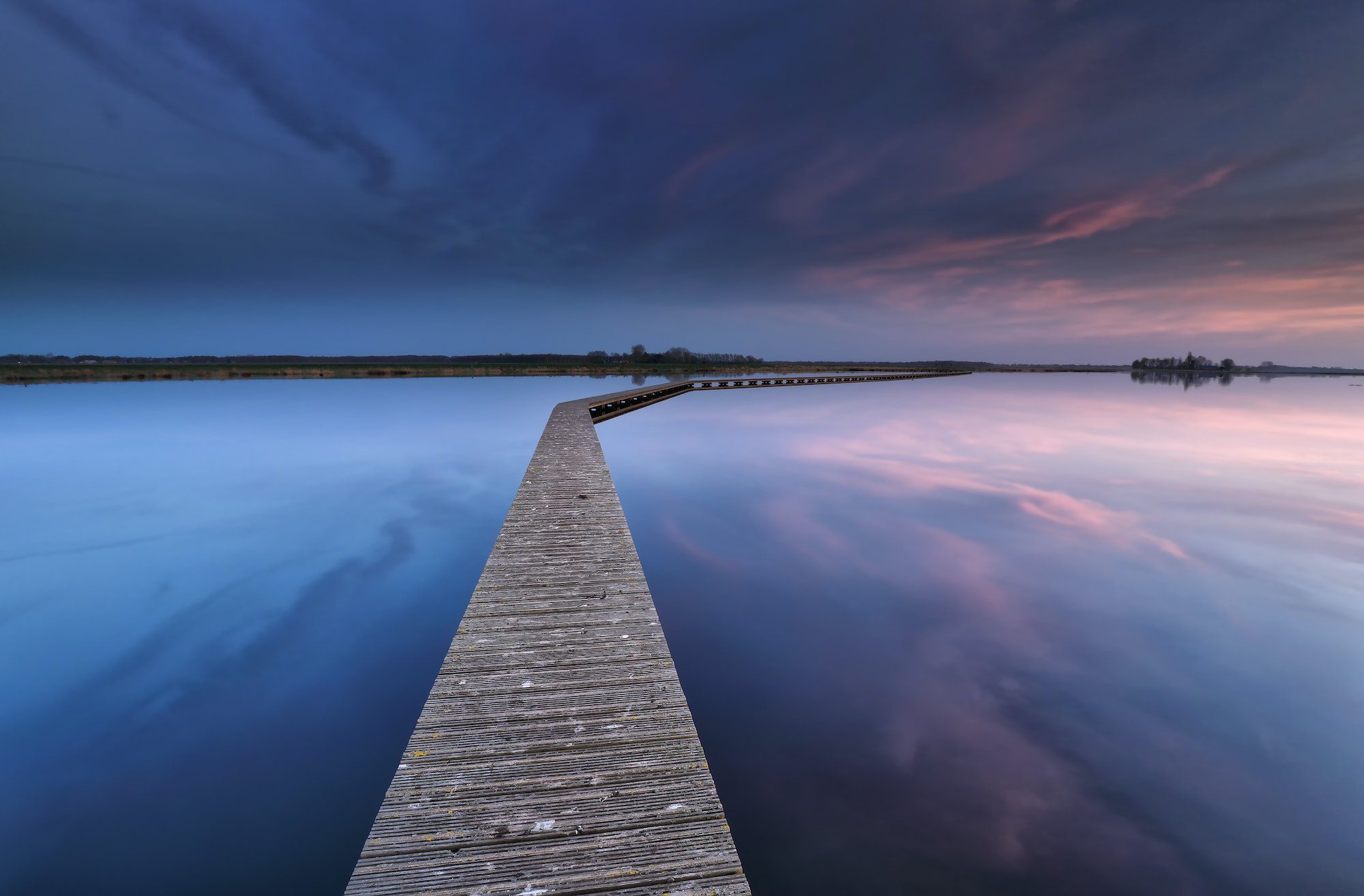 wooden walkpath on water at dawn